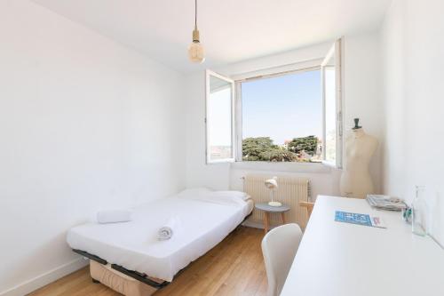 um quarto com 2 camas e uma janela em Cabana & Grand appartement cosy - Parking & Balcon em Villefranche-sur-Saône