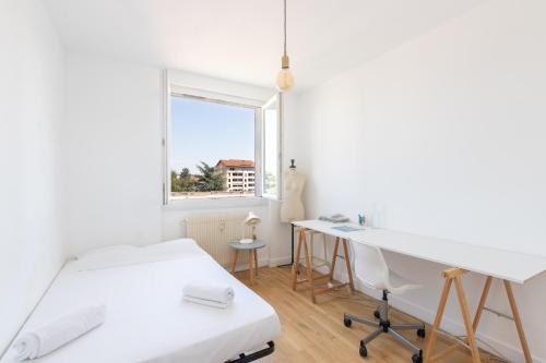 Dieses weiße Zimmer verfügt über einen Schreibtisch und ein Fenster. in der Unterkunft Cabana & Grand appartement cosy - Parking & Balcon in Villefranche-sur-Saône