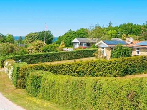 a hedge fence in front of a house at 8 person holiday home in Alling bro in Nørager