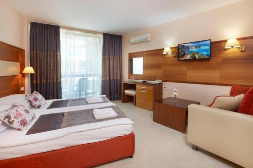 a hotel room with a bed and a tv on the wall at Briz - Seabreeze Hotel in Sunny Beach