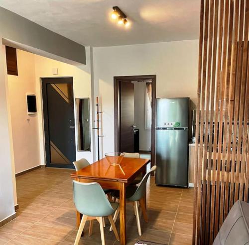 a kitchen with a wooden table and a refrigerator at Korina's Apartment in Daratso