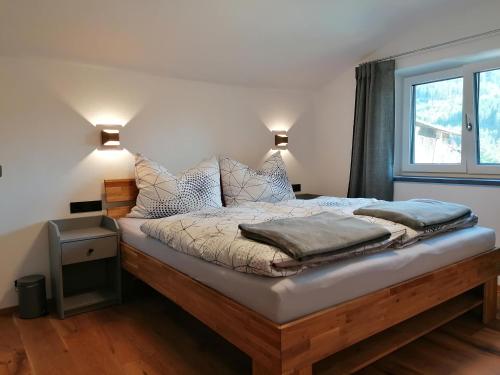 a bedroom with a bed with pillows and a window at Apartment Sepp in Brixen im Thale