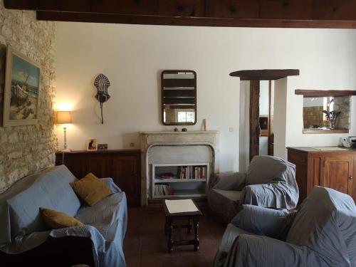 un salon avec deux canapés et une cheminée dans l'établissement La Plume, wunderschönes Häuschen, 900 m vom Meer entfernt, à Dolus-d'Oléron