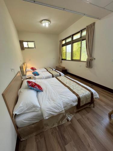 a large bedroom with two beds in it at 觀心農舍 民宿 Ageless Farmhouse in Sanyi