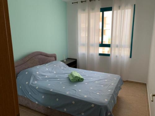 a bed with a blue comforter in a room at על שפת כנרת in Tiberias
