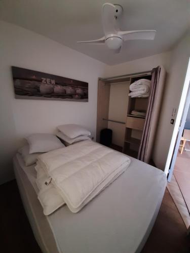 - un lit blanc dans une chambre avec plafond dans l'établissement Appartement Canet Plage sud, à Canet