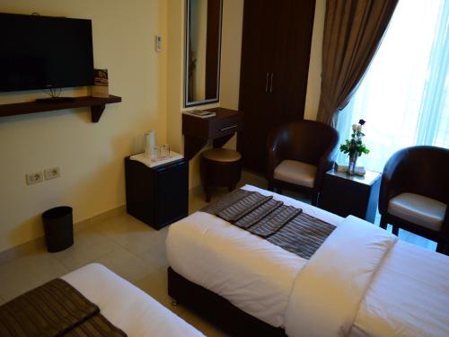a hotel room with a bed and a flat screen tv at Ream Hotel Amman in Amman
