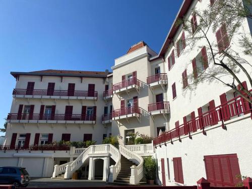 un grand bâtiment blanc avec des escaliers devant lui dans l'établissement Studio de 21m2 au moulleau à 20 m de la plage, à Arcachon