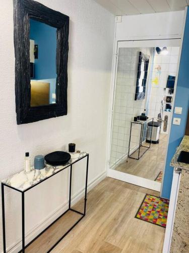 une salle de bain avec un lavabo et un miroir au mur dans l'établissement Studio de 21m2 au moulleau à 20 m de la plage, à Arcachon