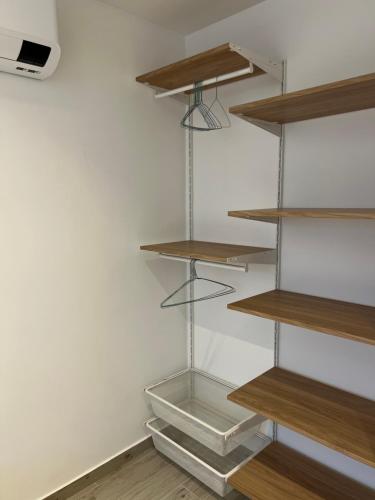 un placard avec des étagères en bois et une boîte en verre dans l'établissement Entre le port et la plage, Golfe de Saint Tropez, à Cogolin