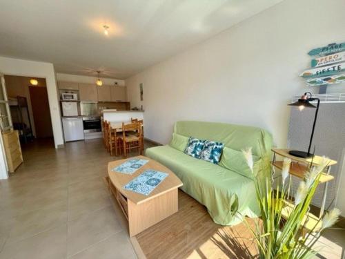 un salon avec un canapé vert et une table dans l'établissement Appartement 2 pièces à Quiberon - 43m², proche plage et commerces, rez-de-jardin avec terrasse et parking - FR-1-478-245, à Quiberon