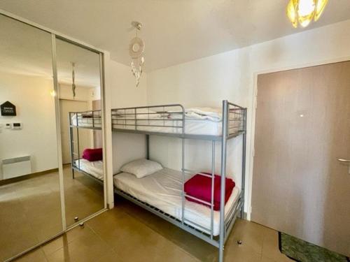 - 2 lits superposés dans une chambre avec un miroir dans l'établissement Appartement 2 pièces à Quiberon - 43m², proche plage et commerces, rez-de-jardin avec terrasse et parking - FR-1-478-245, à Quiberon