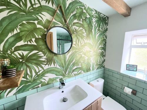 a bathroom with a large mural of palm trees on the wall at The Little Cottage by Truabode Holiday Lets & Short Lets Newquay - Parking, Wifi & Pet Friendly in Newquay