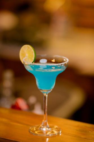 a blue drink in a glass with a lime at Neenlawat Riverside in Surat Thani