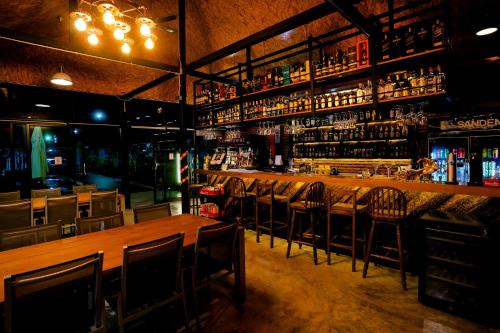 a bar with chairs and a wooden table in a room at Neenlawat Riverside in Surat Thani