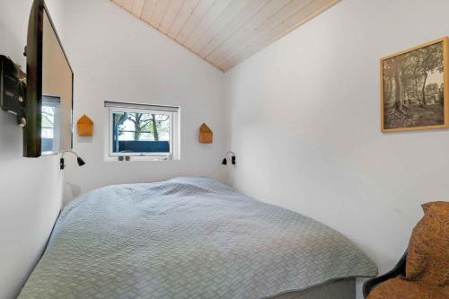 1 dormitorio con cama y ventana en Summerhouse Just A Stones Throw From The Waters Edge, en Karrebæksminde