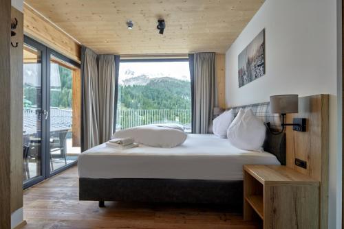 sypialnia z łóżkiem i dużym oknem w obiekcie Alm-Lodges Montafon by Pferd auf Wolke w mieście Gargellen