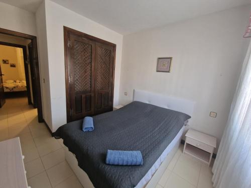 Un dormitorio con una cama con una almohada azul encima. en First line sea apartments, en Torrevieja