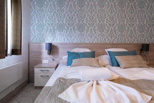 deux lits jumeaux dans une chambre avec un mur dans l'établissement Apartman Nobilis, à Hévíz