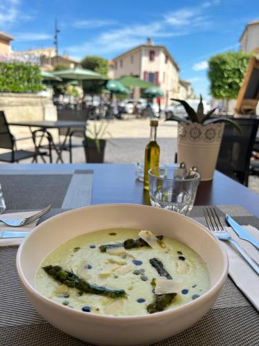 サン・ジルにあるHôtel Restaurant Le Saint Gilloisのテーブルの上に座るスープ一杯