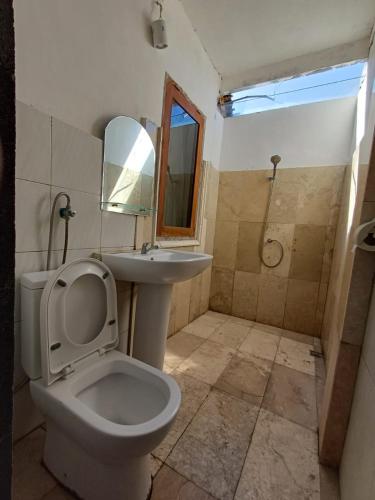 a bathroom with a toilet and a sink and a shower at Kanaan House in Nusa Dua
