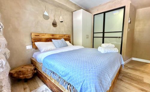 a bedroom with a large bed with a blue comforter at Boutique apartment in heart of Haifa in Haifa