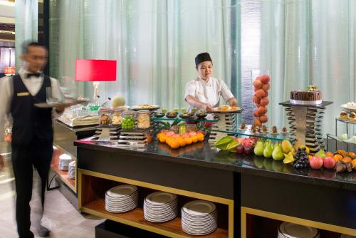 a couple of chefs preparing food in a buffet at The Trans Luxury Hotel Bandung in Bandung