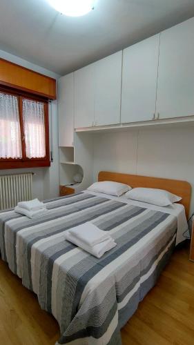 a bedroom with a large bed with white cabinets at Appartamenti Massimiliano in Peschiera del Garda
