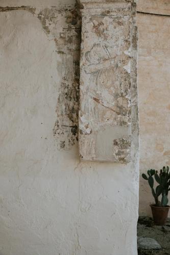 a crumbling wall with a potted plant on it at Il Giardino del Priore Dimora Rurale in Ugento