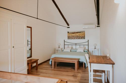 a bedroom with a bed and a table at Il Giardino del Priore Dimora Rurale in Ugento