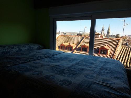 1 dormitorio con cama y ventana grande en Loft-Terraza Laurel, en Logroño