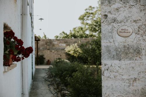 a building with a sign on the side of it at Il Giardino del Priore Dimora Rurale in Ugento