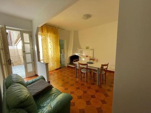ein Wohnzimmer mit einem Sofa, einem Tisch und Stühlen in der Unterkunft Casa Elena in Gonnesa