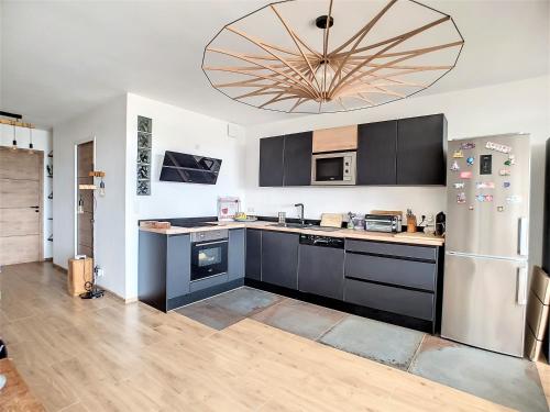 La cuisine est équipée de placards bleus et d'un réfrigérateur en acier inoxydable. dans l'établissement Le Grand Large, face à vous, à Cassis