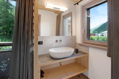 a bathroom with a white sink and a window at Agriturismo Bosco d'oro 4 in Livigno