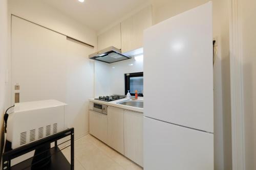 a kitchen with white cabinets and a sink at Setagaya House by Tranova in Tokyo