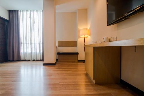 a hotel room with a television and a desk in a room at De' Garden Hotel, Butterworth in Butterworth