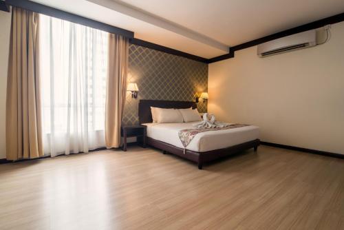a bedroom with a bed and a large window at De' Garden Hotel, Butterworth in Butterworth