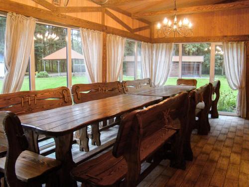 una sala da pranzo con un grande tavolo in legno e sedie di База відпочинку Гаївка котедж a Klevanʼ