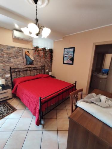 una camera con un letto rosso e un muro di mattoni di B&B VILLA RITA a Silvi Marina
