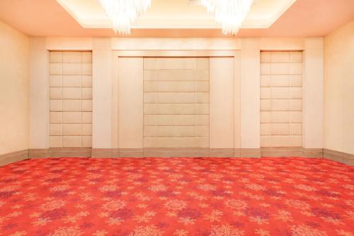 an empty room with a red carpet and chandeliers at Lemon Tree Premier 2, Sector 29 Gurugram in Gurgaon