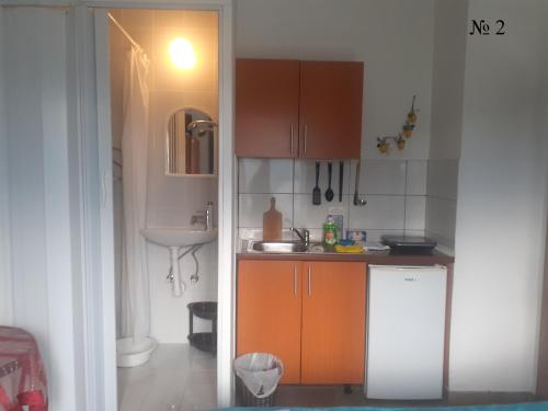a small kitchen with orange cabinets and a sink at OLGA apartmani in Sutomore