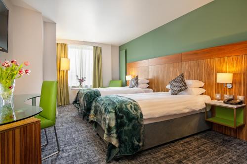 two beds in a hotel room with green accents at The Glasshouse in Sligo