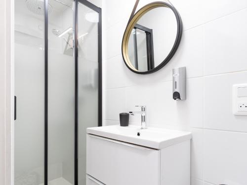 a white bathroom with a sink and a mirror at La Petite Parenthèse Vienna Authentica in Vienne