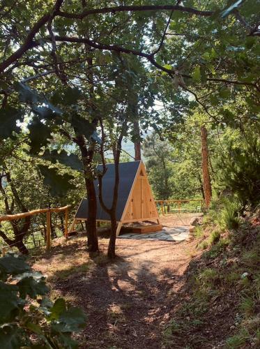 a wooden cabin in the middle of a forest at SKY HOUSE Experience in Orco Feglino