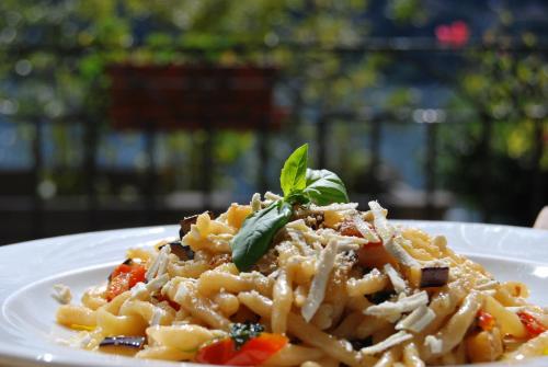 a plate of pasta with a green leaf on top at Hotel Orso Bruno in Carate Urio