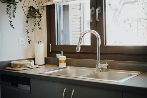 eine Küchentheke mit einem Waschbecken und einem Fenster in der Unterkunft Το Σπίτι της Ευτυχίας Σουίτα in Karpenisi