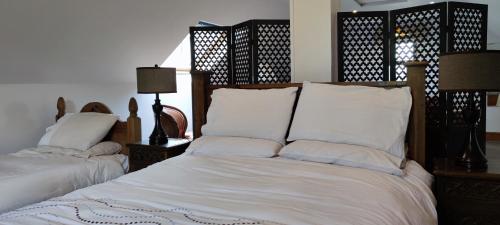 1 dormitorio con 2 camas con sábanas y almohadas blancas en The Garden Gates Guest Accommodation, en Castlebar