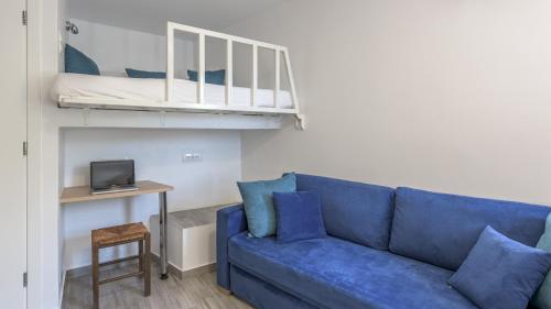 een woonkamer met een blauwe bank en een stapelbed bij Armenakishouses in Pollonia