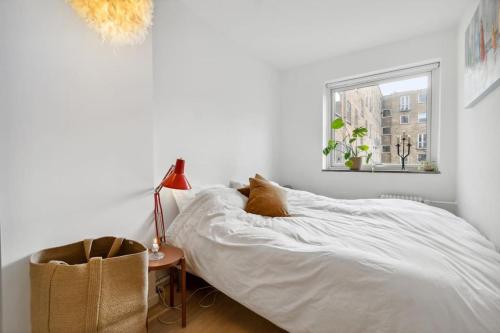 1 dormitorio con cama, lámpara y ventana en Great central apartment walking distance to metro, en Copenhague
